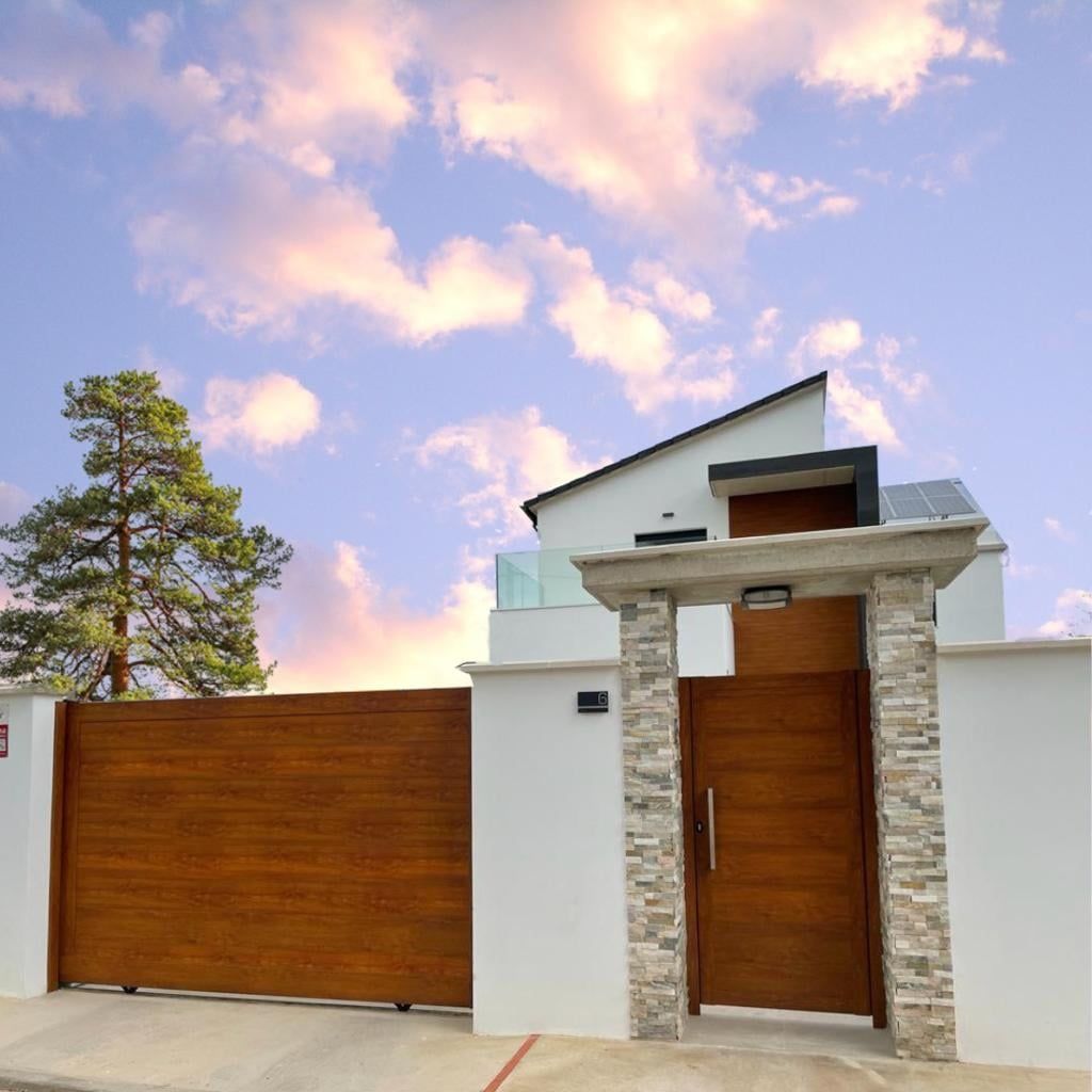 Una casa blanca con una valla de madera y una puerta de madera