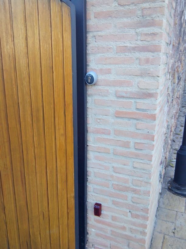 Una puerta de madera está al lado de una pared de ladrillos.