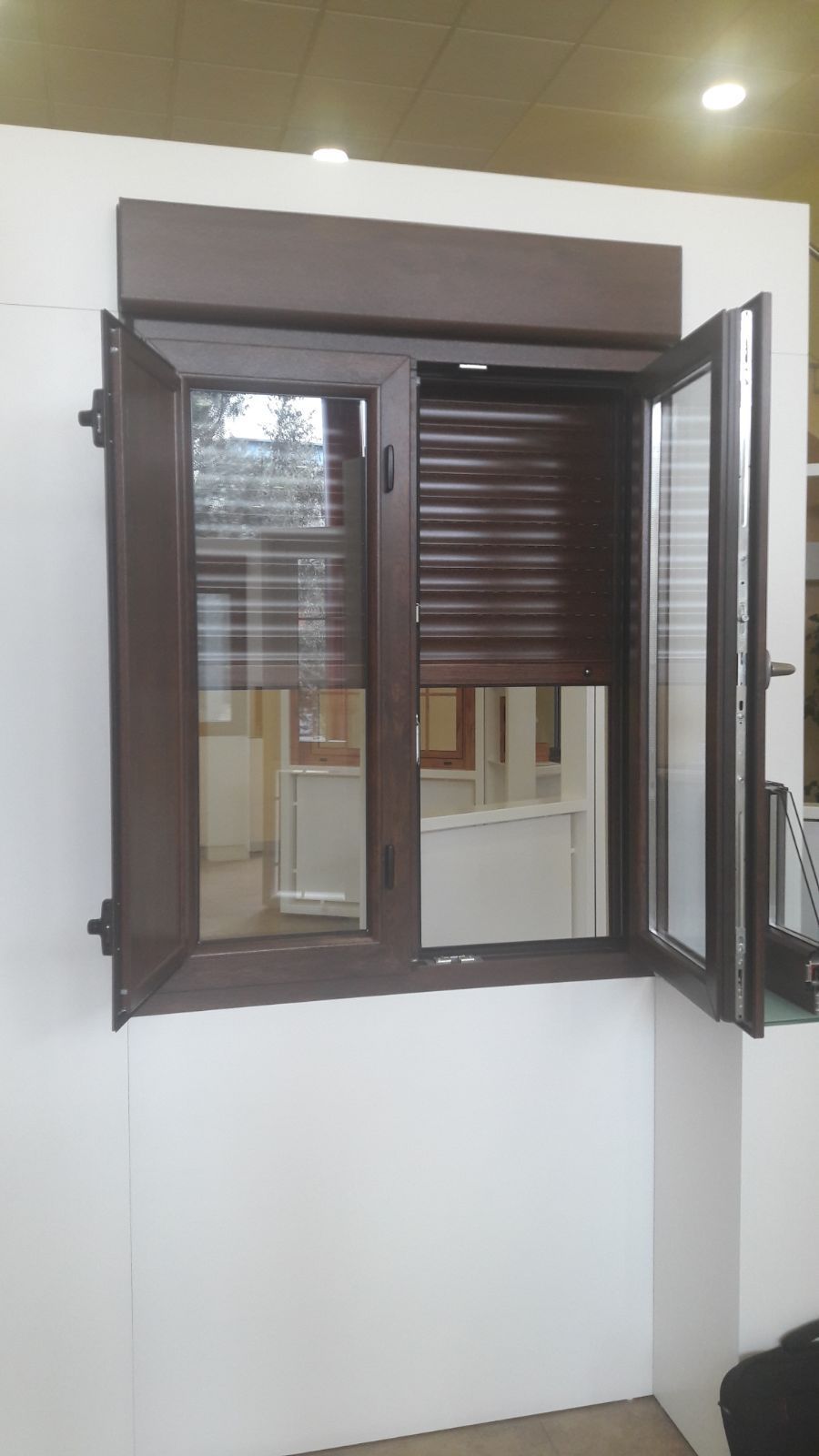 Una ventana con persiana está abierta en una habitación.