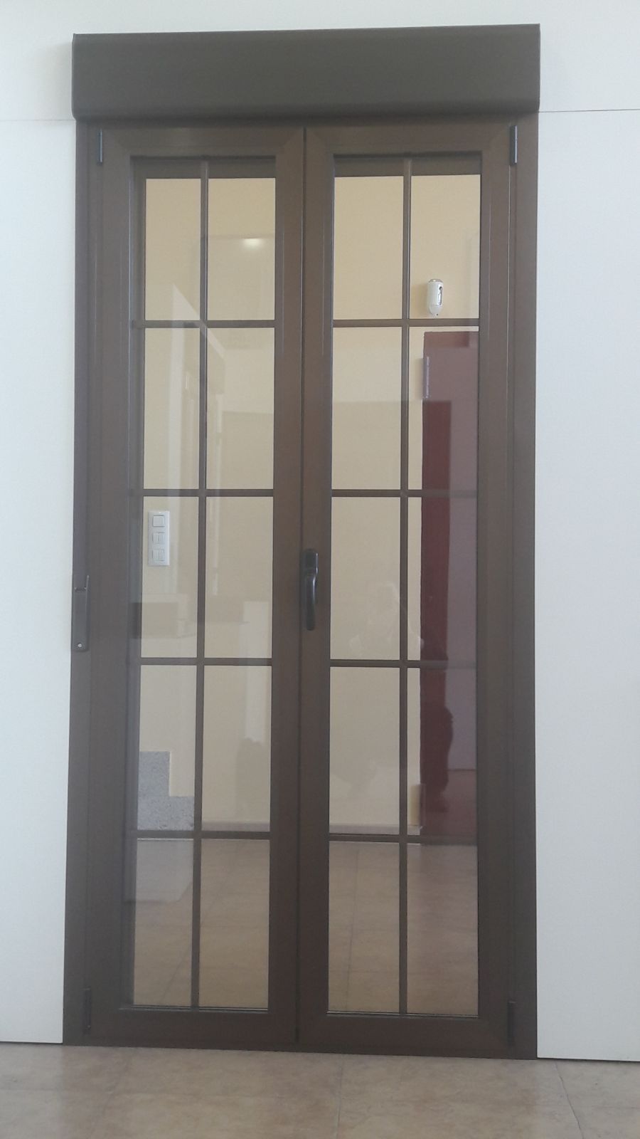 Un par de puertas corredizas de vidrio en una habitación con una pared blanca.