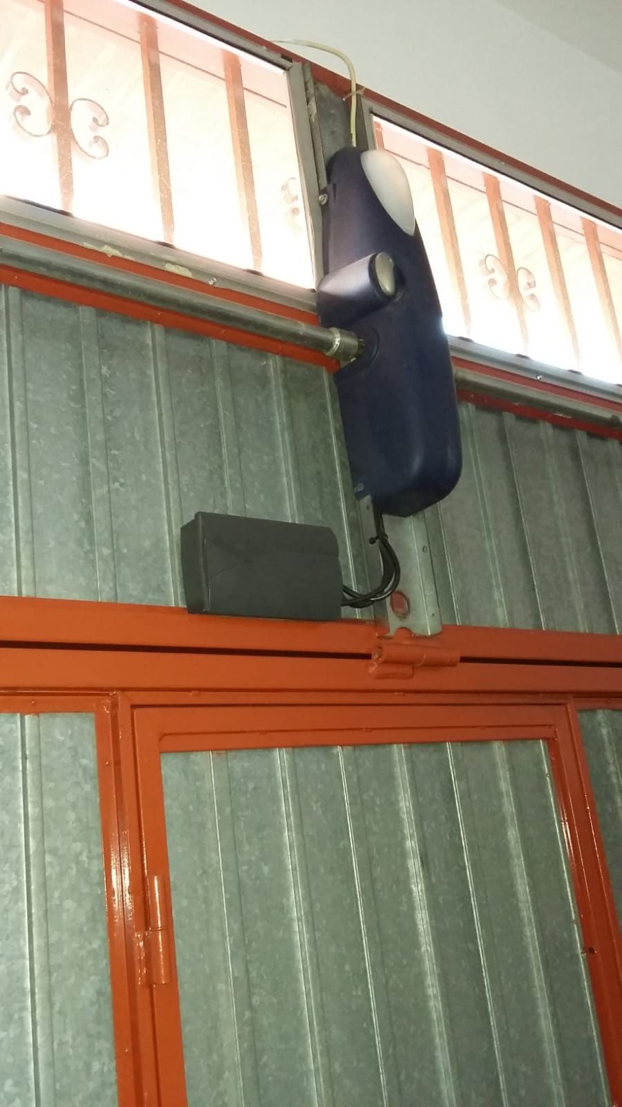 Un objeto azul cuelga del techo de un edificio.