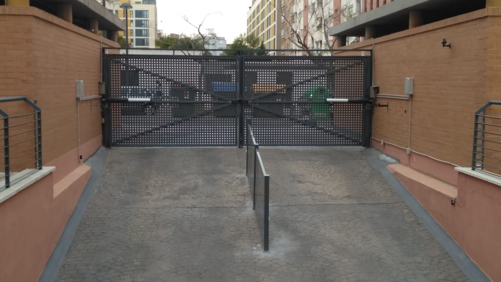 Una entrada cerrada a un estacionamiento con una pared de ladrillos