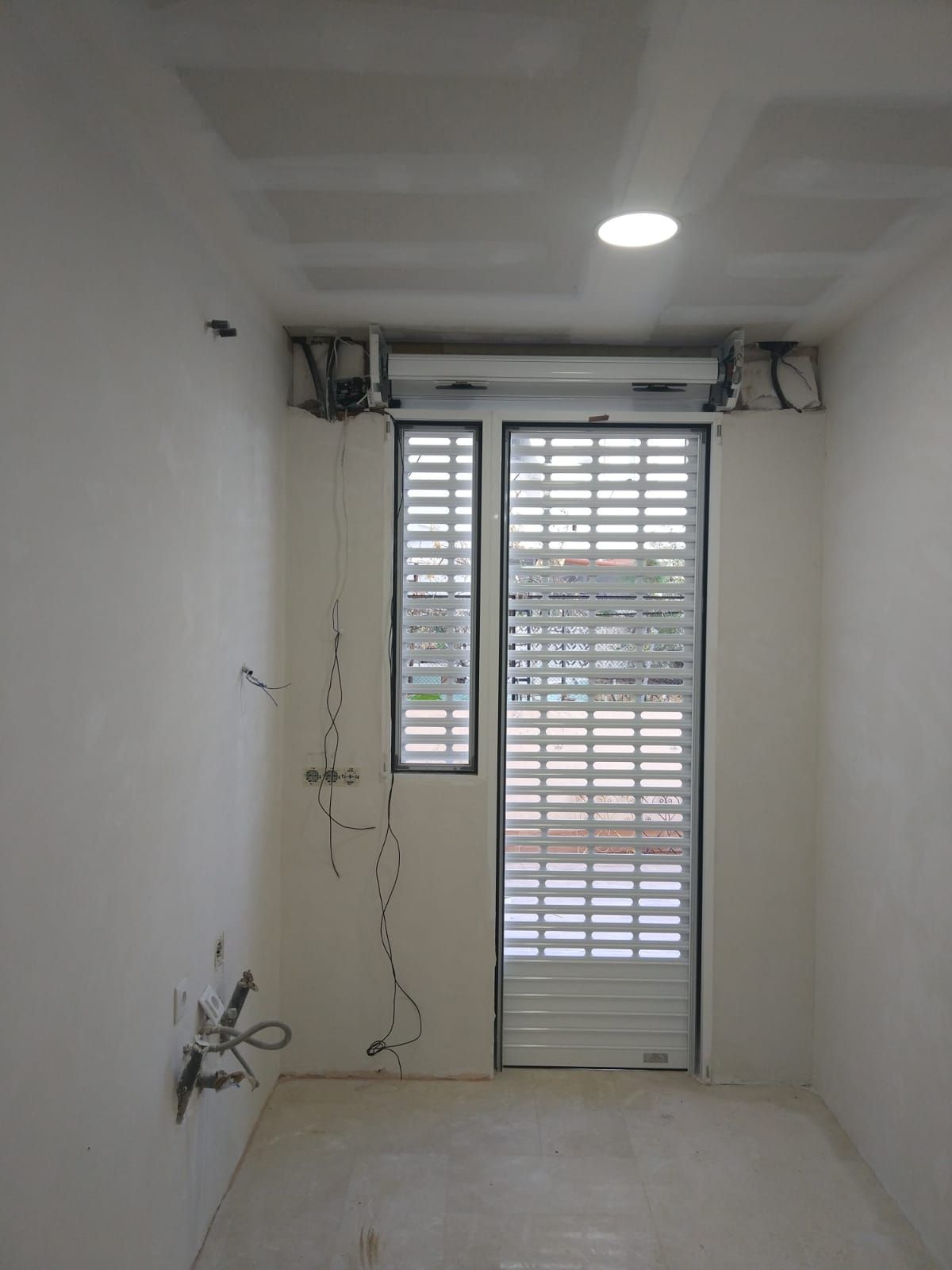 Una habitación vacía con una puerta y una ventana.