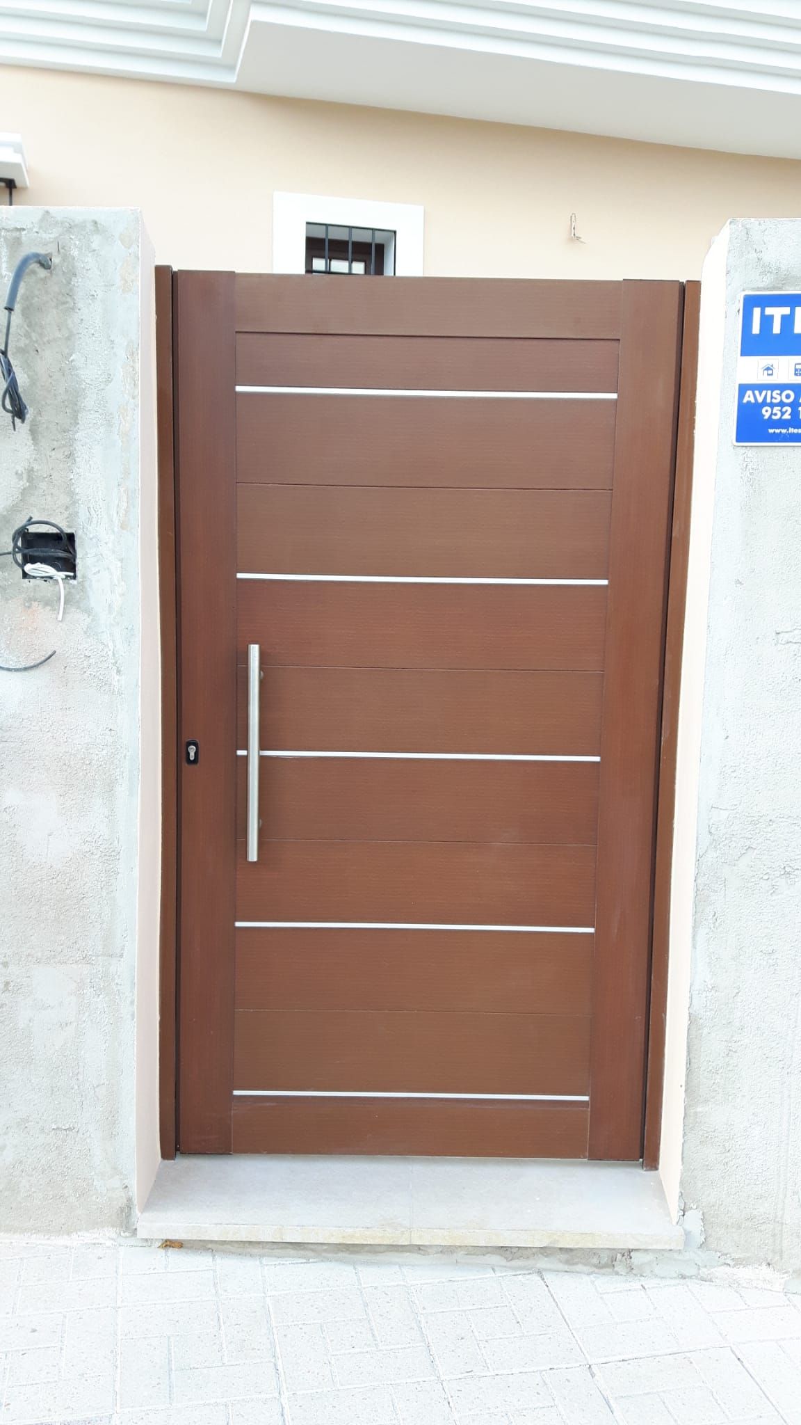 Una puerta de madera con manija de acero inoxidable
