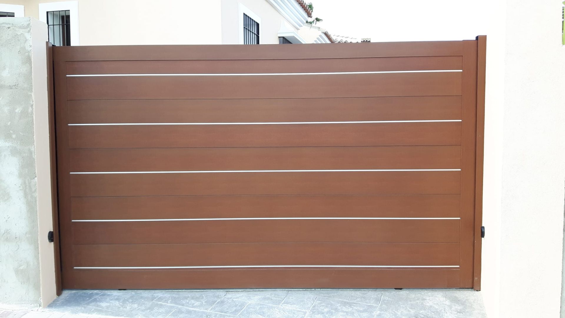 Una puerta de madera marrón con rayas de acero inoxidable.