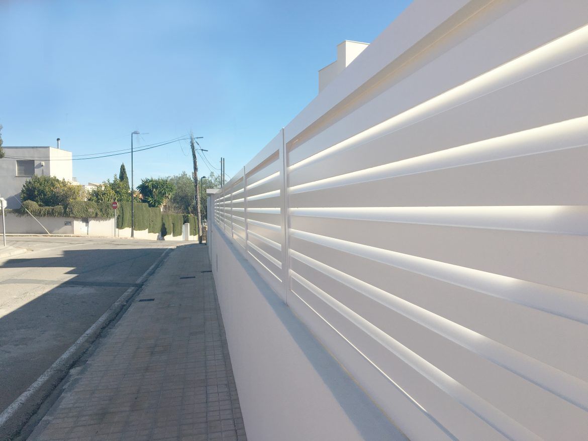 Una valla blanca está a lo largo del costado de una carretera