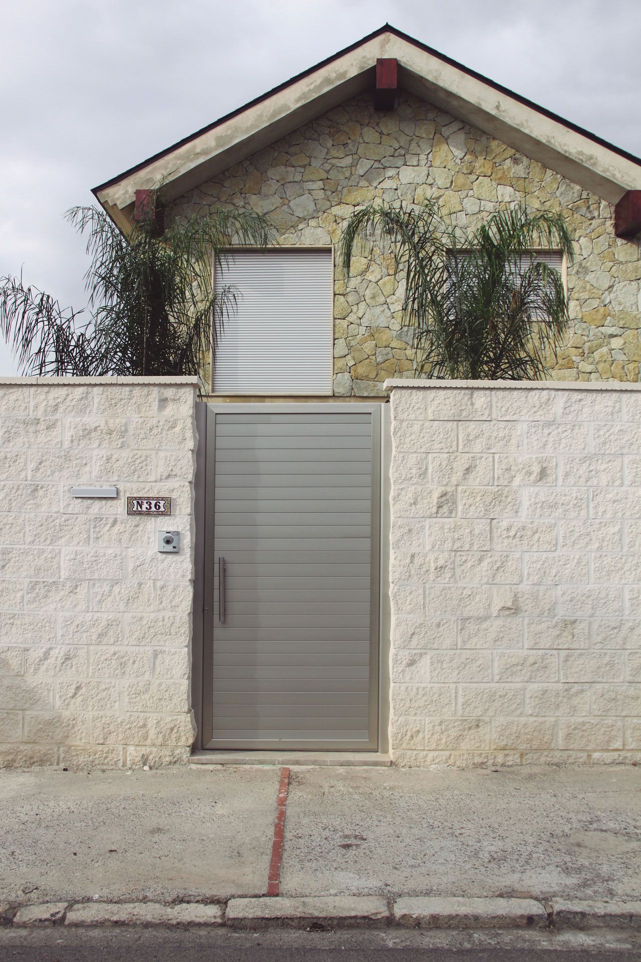 Una casa con una pared de ladrillo y una puerta de acero inoxidable