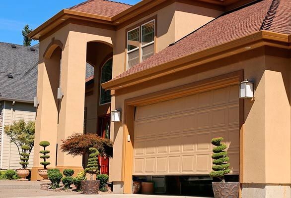 Una casa grande con una puerta de garaje que está abierta.