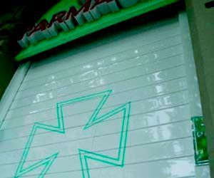 Una cruz verde se dibuja en el costado de un edificio.