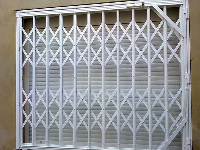Una puerta de metal blanco está encima de una ventana.