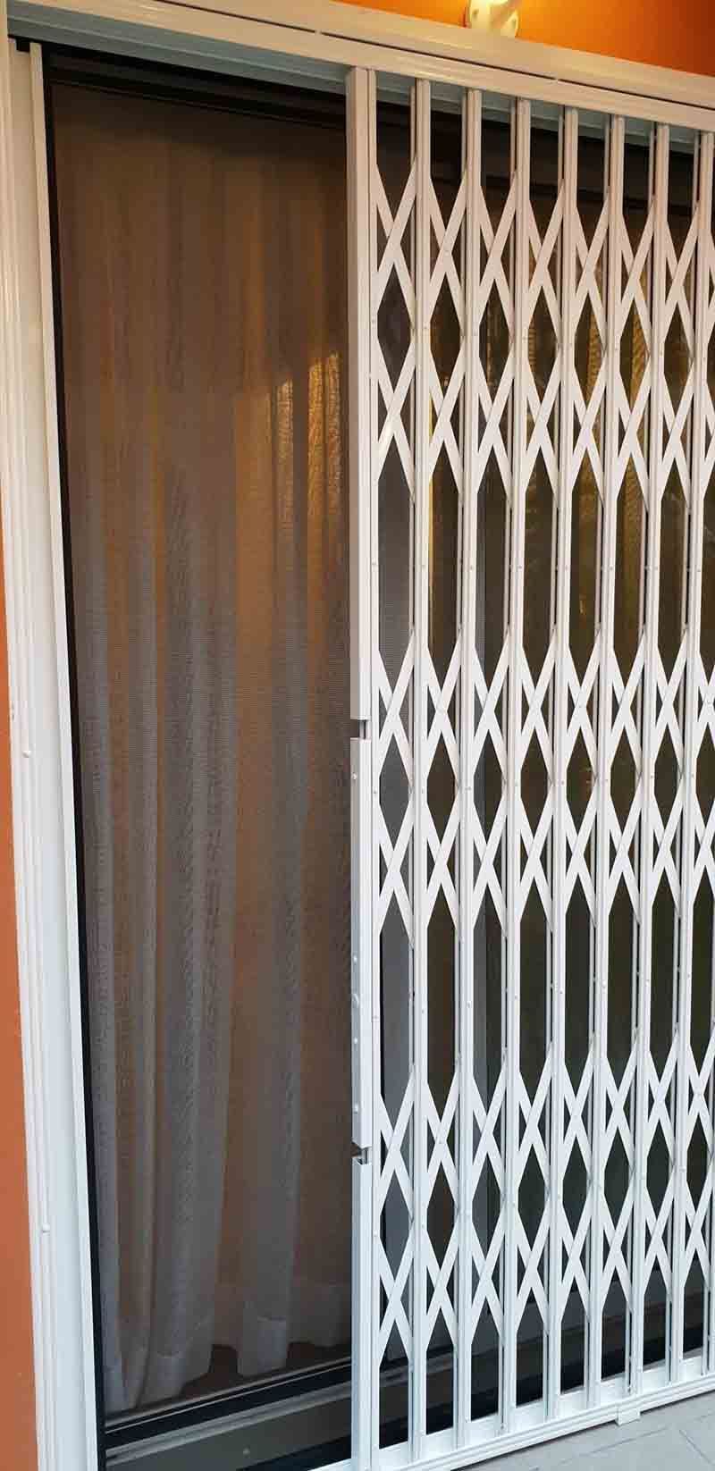 Una puerta corrediza de vidrio con una puerta de metal detrás de ella.
