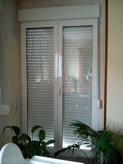 Un baño con una puerta corrediza de vidrio con persianas.