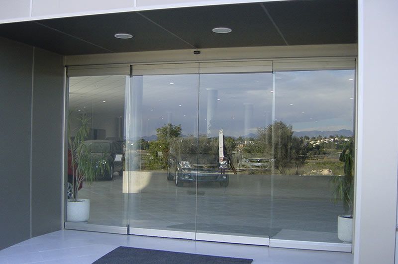 Una puerta corrediza de vidrio con un automóvil detrás.