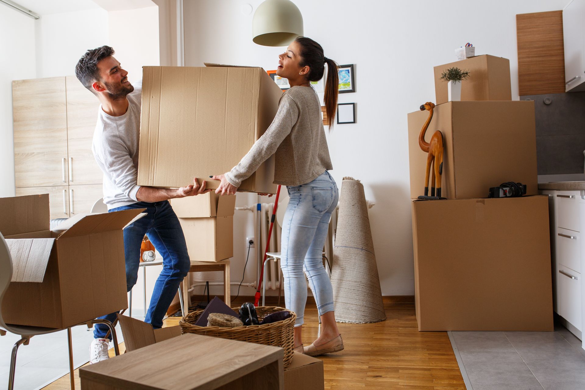 Un couple en train de porter un carton de déménagement