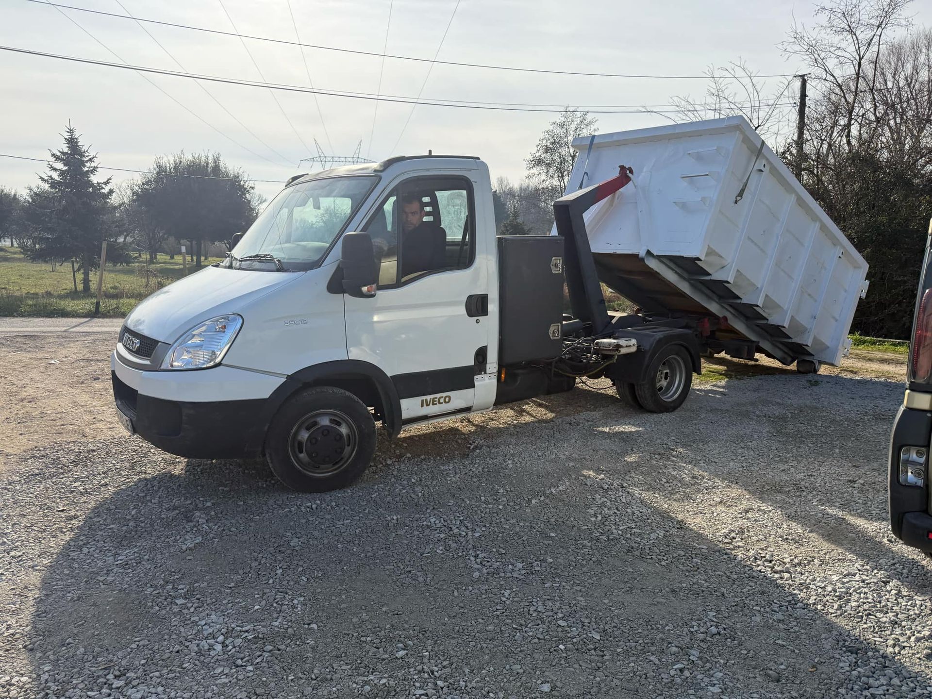 Benne blanche posée par un camion