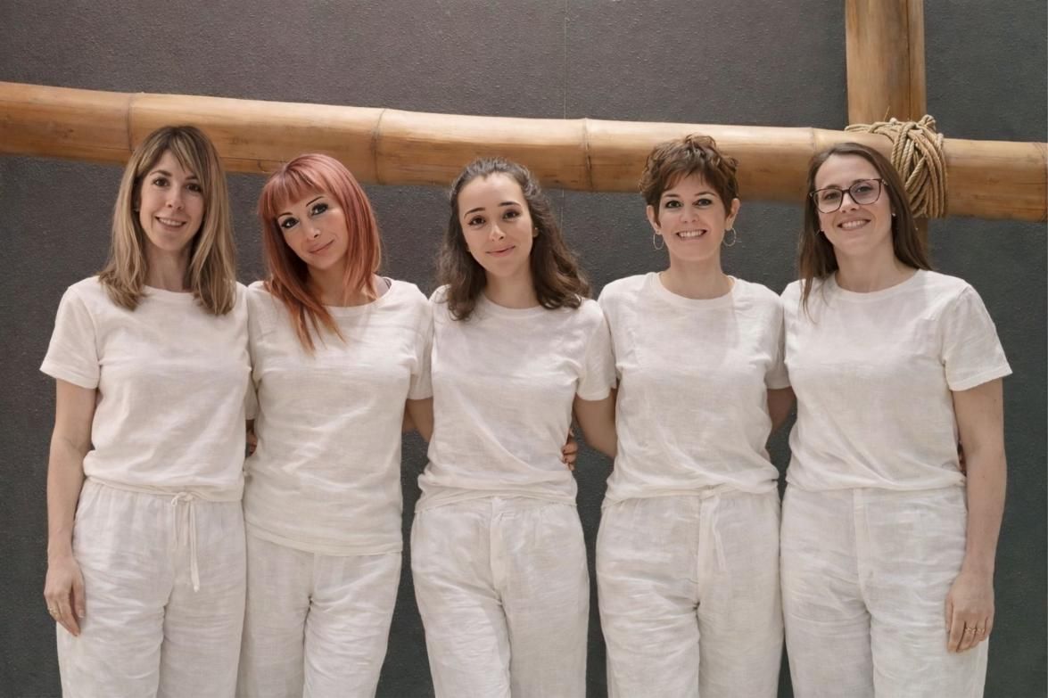 Cinco personas abrazadas . Forman el equipo del centro de yoga.