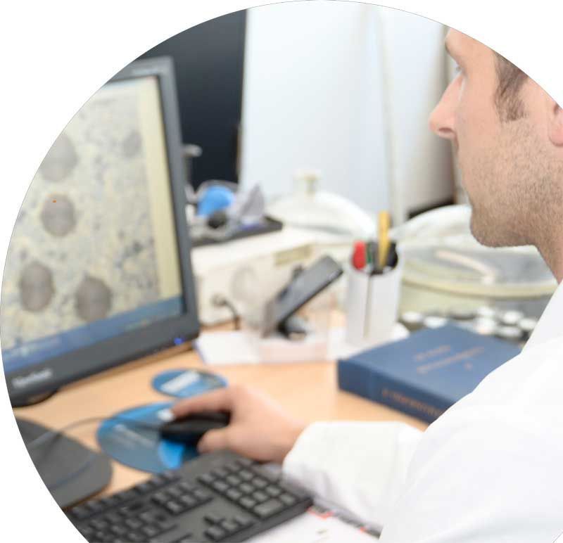 a man in a lab coat is looking at a computer screen