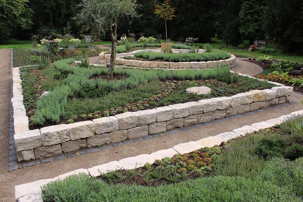 Ein Garten mit vielen Pflanzen und einer Steinmauer