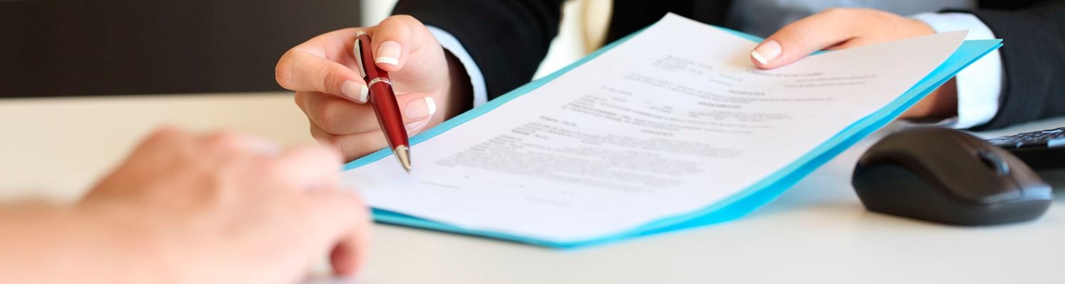 Una persona está firmando un documento con un bolígrafo.