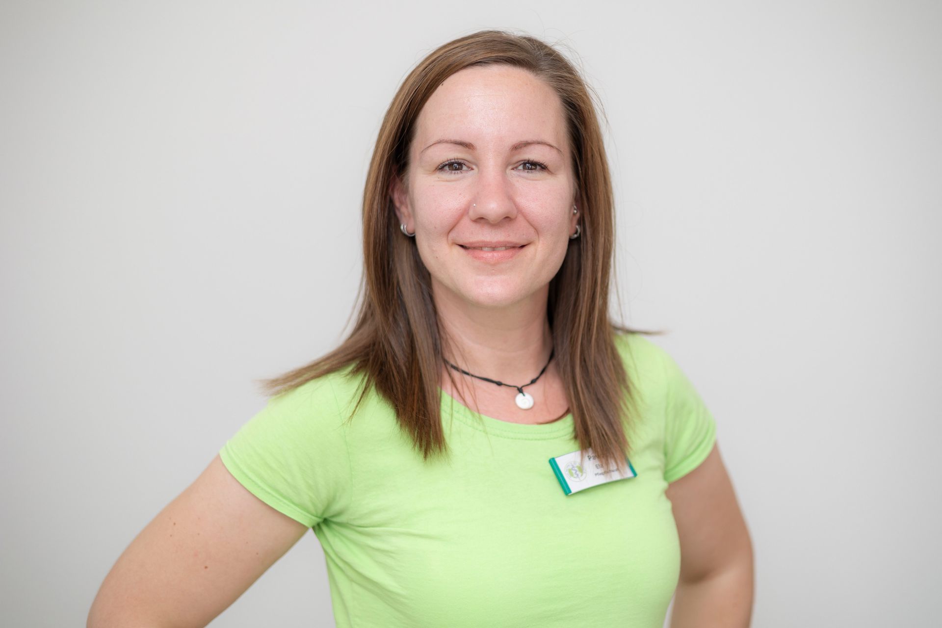 Eine Frau in einem grünen Hemd lächelt in die Kamera.