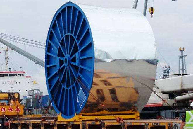 A large blue spool is sitting on top of a truck.