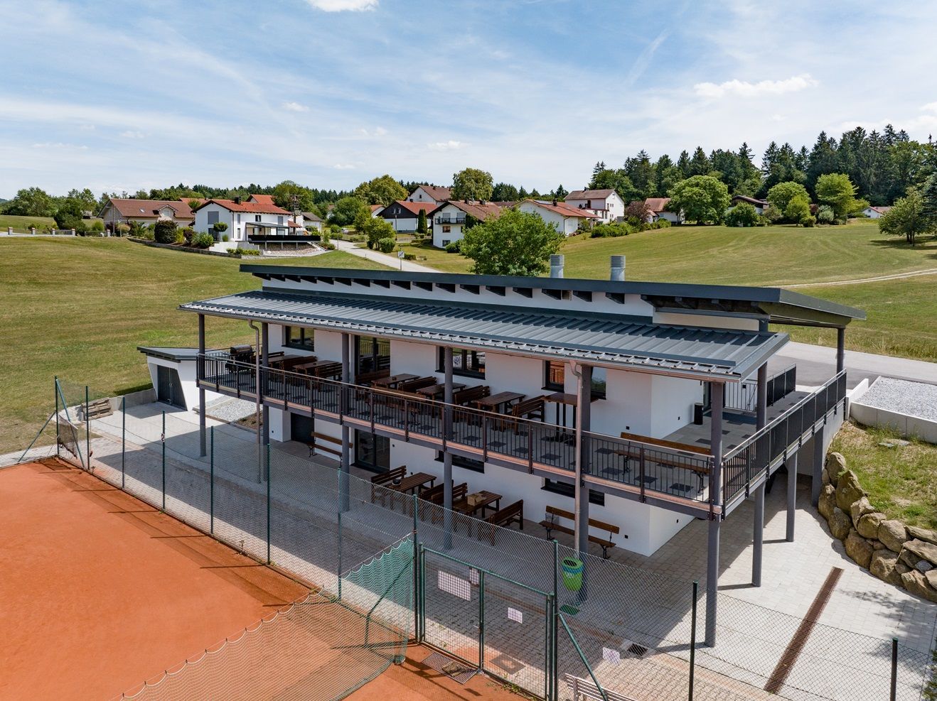 Tennisclub mit Balkon mit Blick auf den Platz und die ländliche Landschaft.