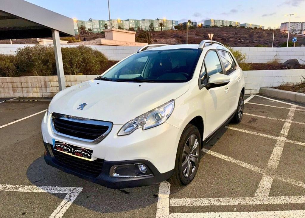 Peugeot 2008 SUV blanco estacionado en un estacionamiento en un día soleado.