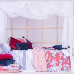 Una cama con dosel y almohadas encima.