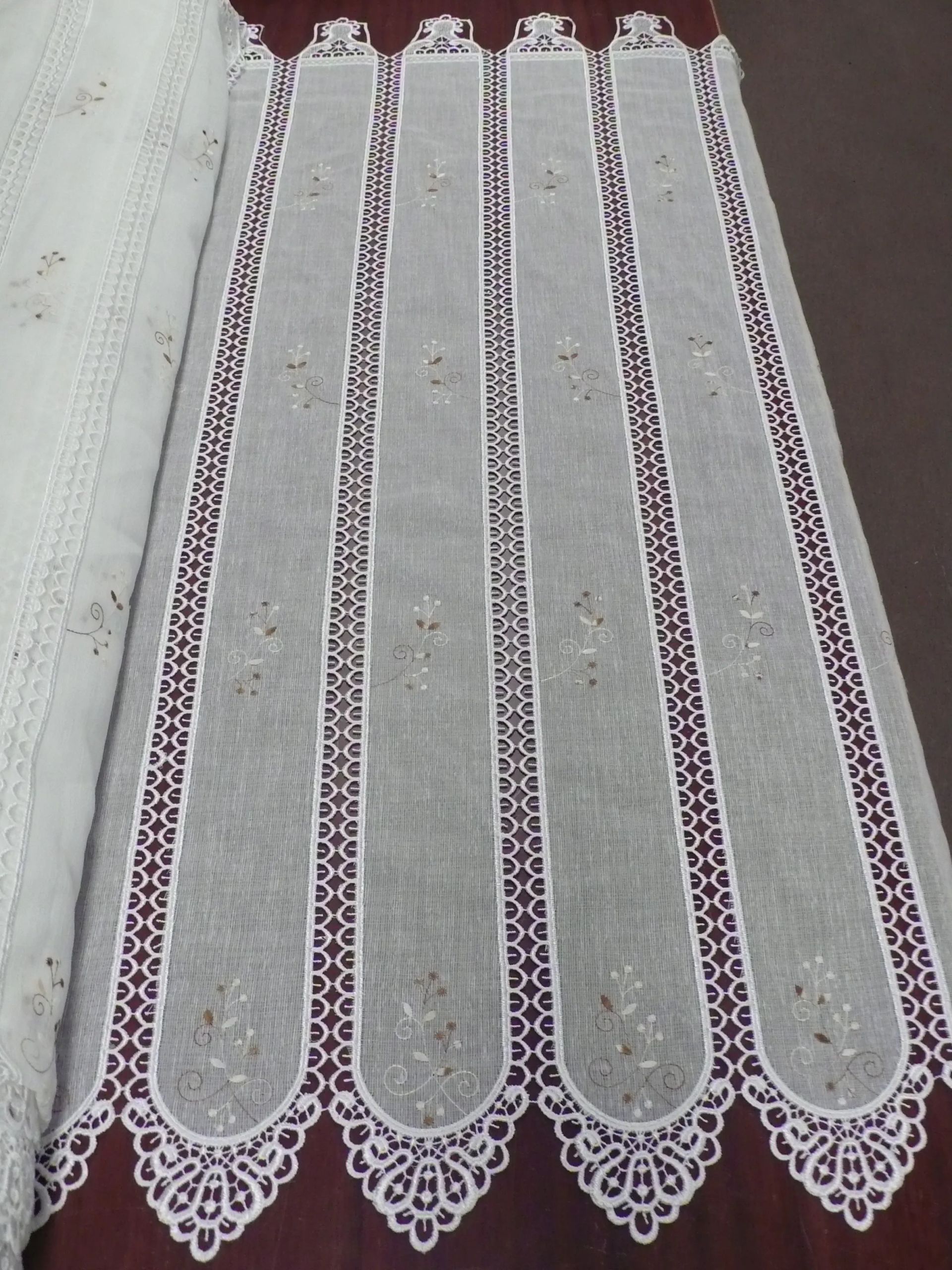 Una cortina de encaje blanco está sobre una mesa.