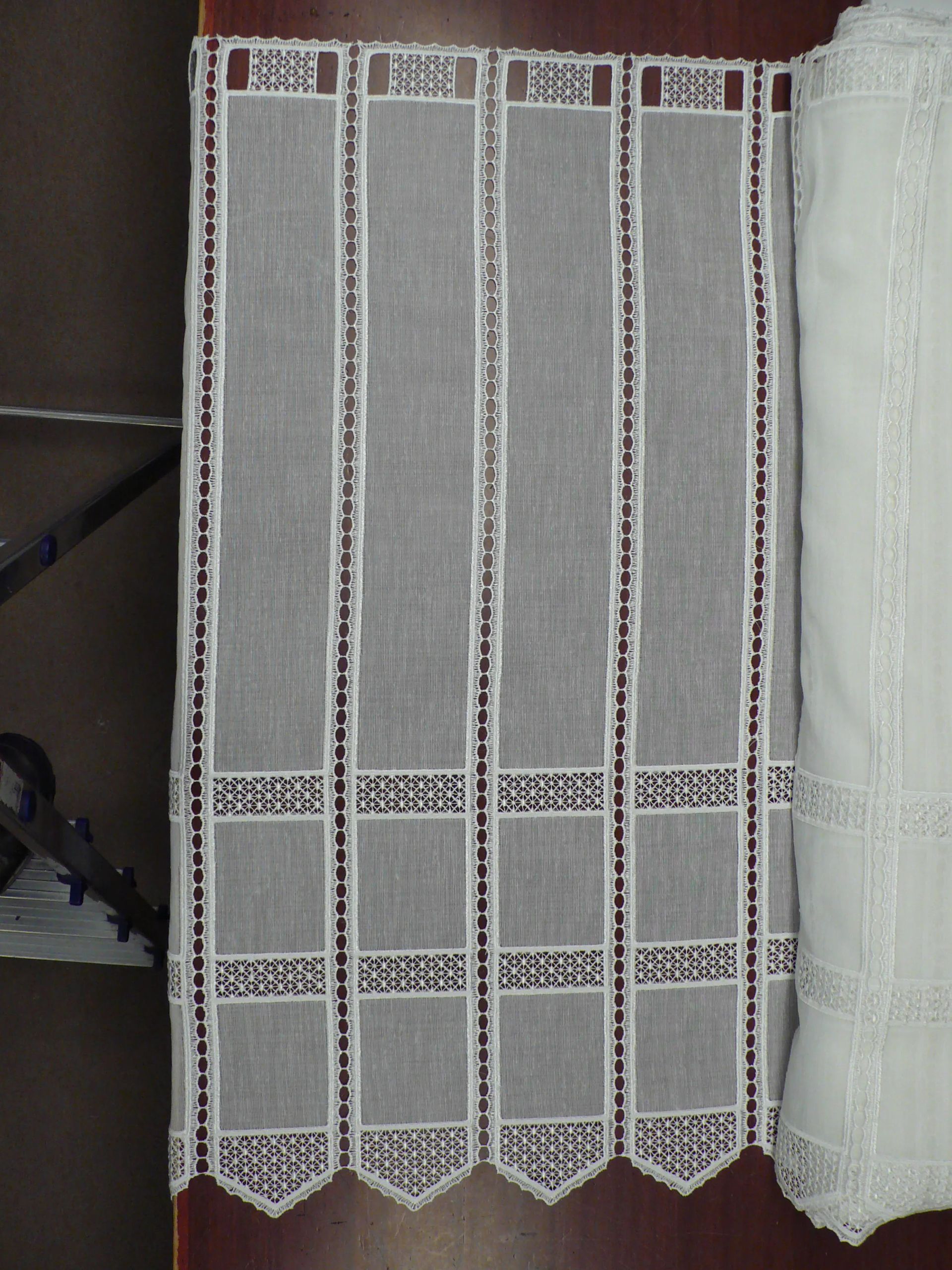 Una cortina blanca está sobre una mesa de madera.