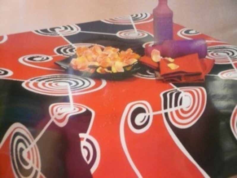 Un mantel rojo con espirales y un plato de comida sobre él.