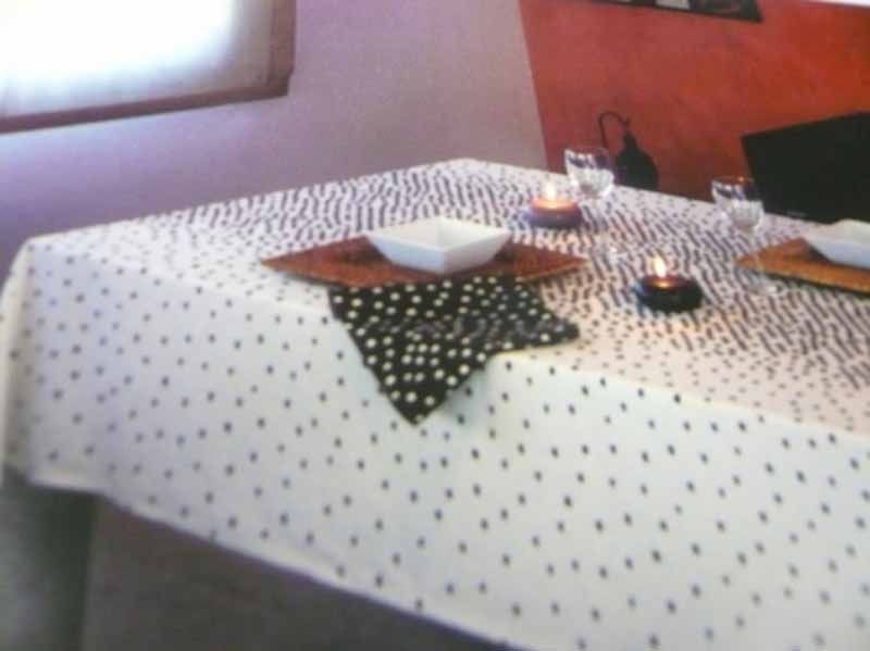 Un mantel blanco con lunares negros.