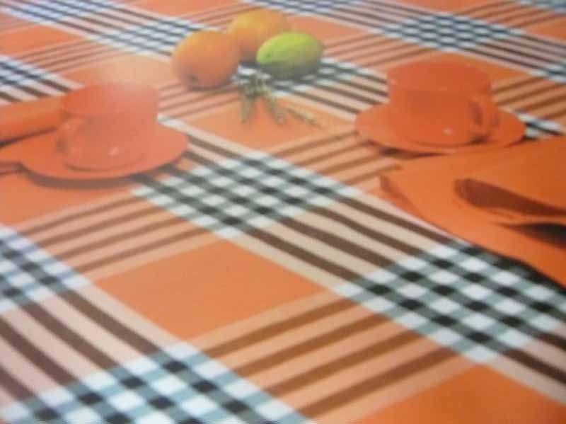 Un mantel a cuadros con tazas y platillos encima.