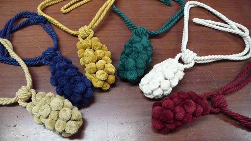 Un montón de collares de cuerda de diferentes colores sobre una mesa.