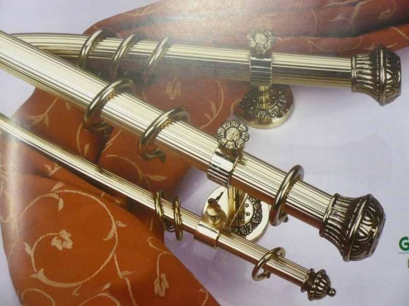 Un par de barras de cortina de latón con anillos en ellas.