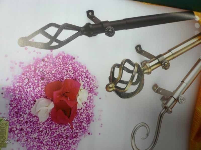 Una imagen de una barra de cortina con una flor en el fondo.