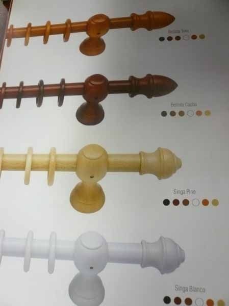 Una fila de barras de cortina de madera en diferentes colores.