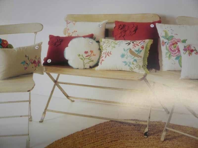 Un banco de madera con un montón de almohadas encima.