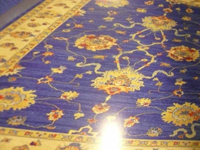 Una alfombra azul con flores y hojas.