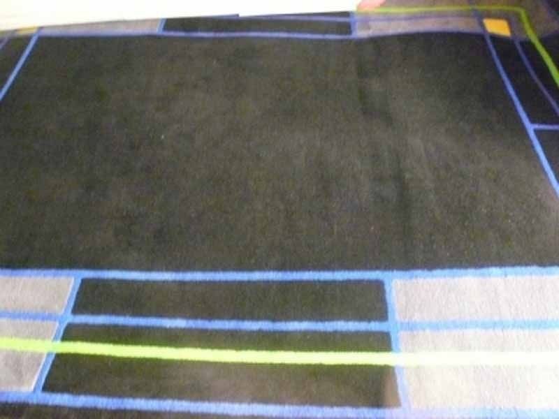 Una alfombra negra con rayas azules y verdes.