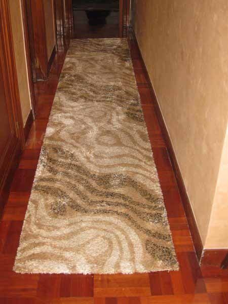 Un pasillo largo con una alfombra en el suelo.