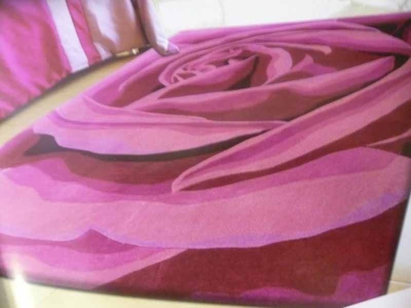 Una alfombra rosa con un diseño de rosa.