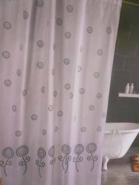 Una cortina de ducha blanca con círculos y flores.