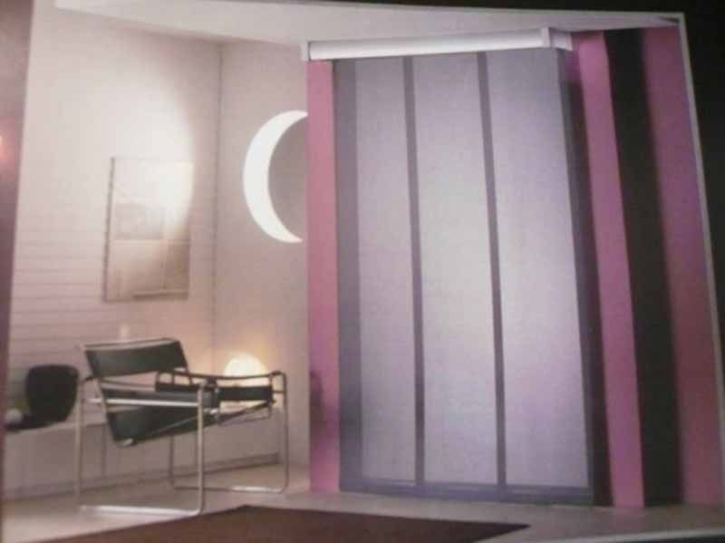 Una habitación con una silla y una luna creciente en la pared.