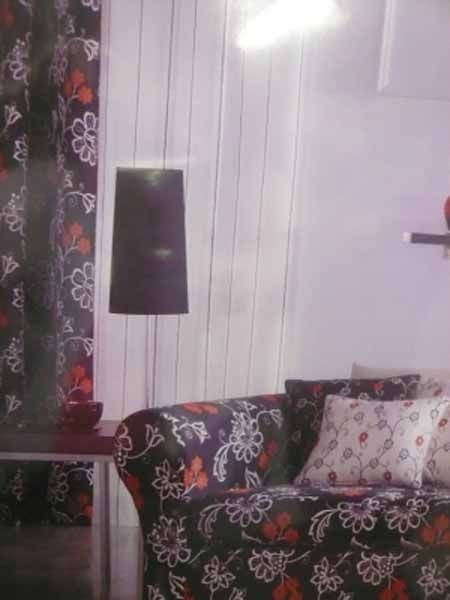 Una sala de estar con un sofá y una lámpara.