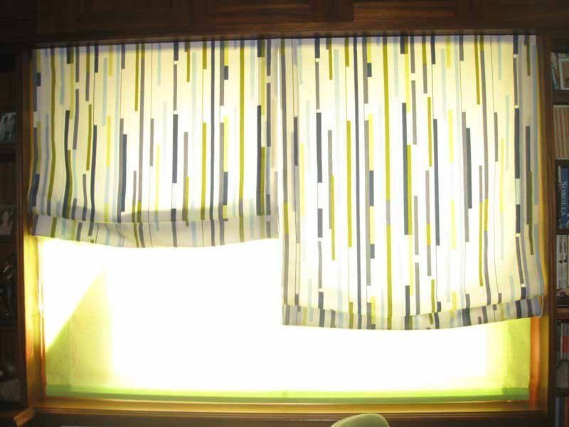 Un par de cortinas cuelgan de una ventana en una sala de estar.