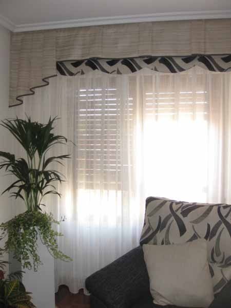 Una sala de estar con un sofá y una planta frente a una ventana.