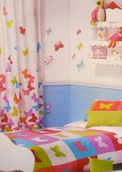 Un dormitorio infantil con una colcha colorida con mariposas.