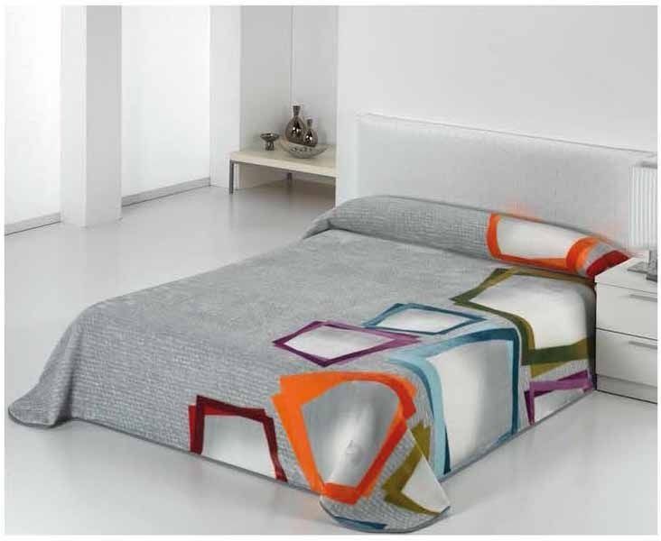 Una cama con una manta colorida encima en un dormitorio.