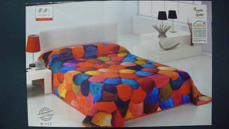 Una cama con una manta colorida encima